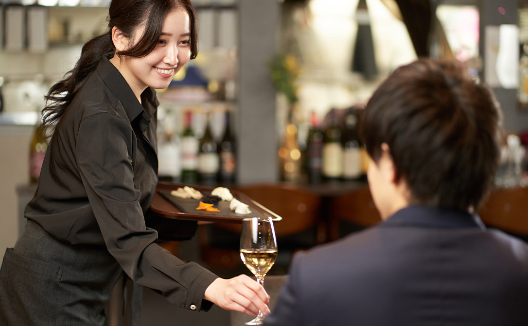 Asian woman serving wine in a bar or restaurant