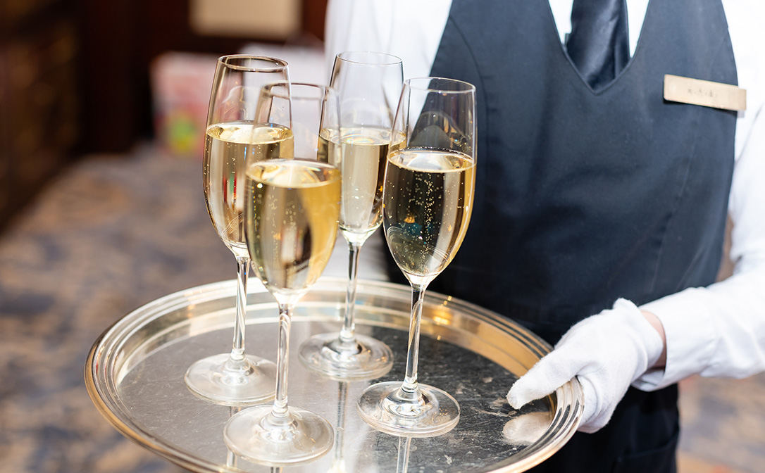Serving a tray of sparkling wine glasses