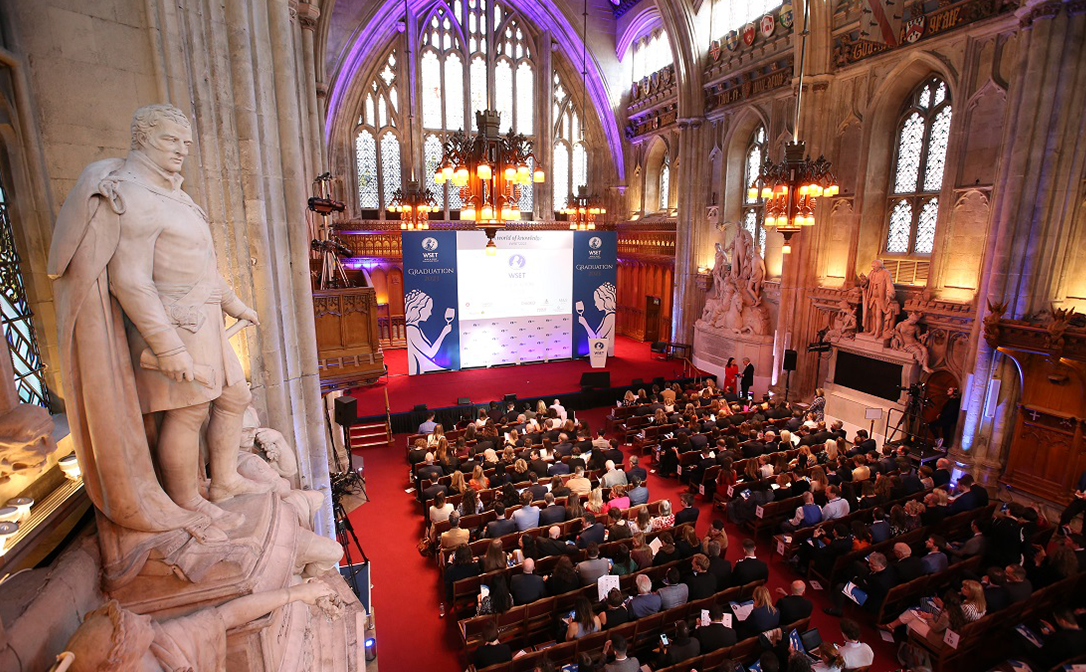 Graduates seated in the Guildhall, facing a large stage