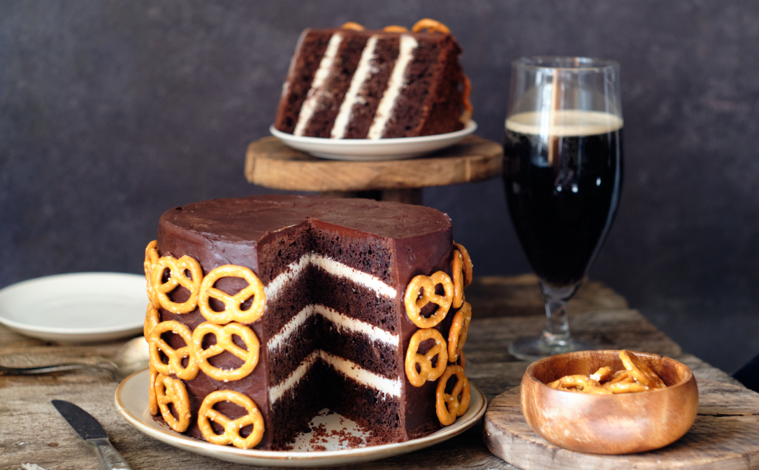 Chocolate cake decorated with mini pretzels, and a dark beer.
