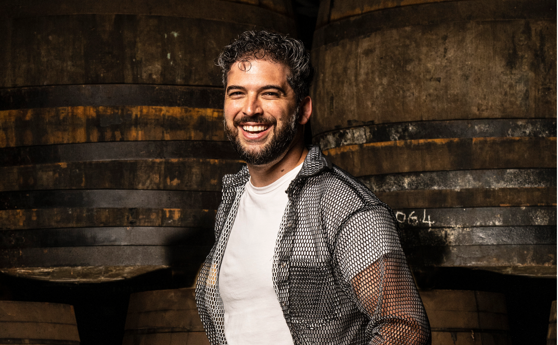 A person standing in front of large wooden barrels