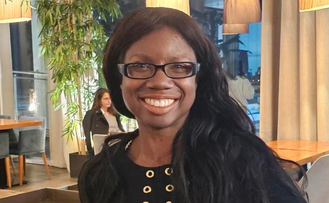 A person in black clothing, smiling towards the camera