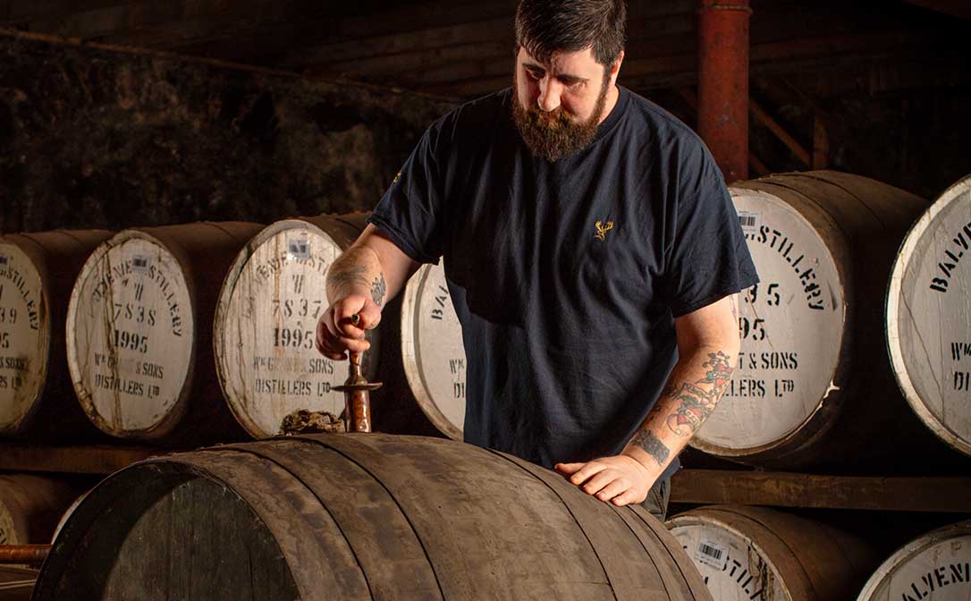 Distiller checking whisky barrels