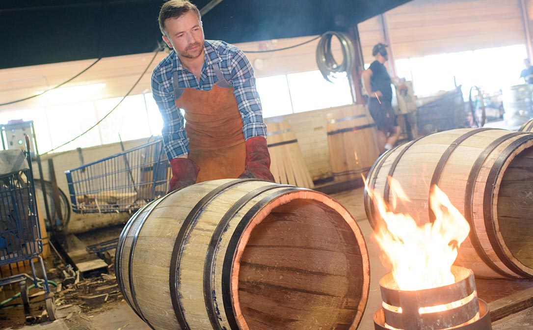 A cooper building an oak barrel